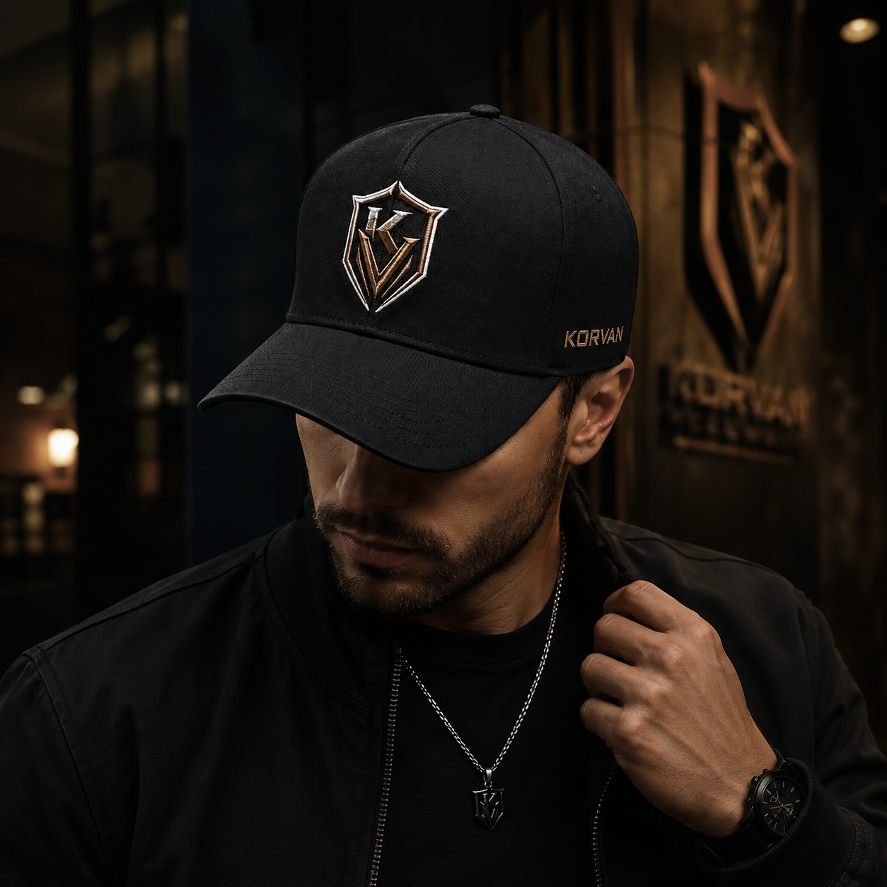 Man wearing a black cap with a logo in a dark setting